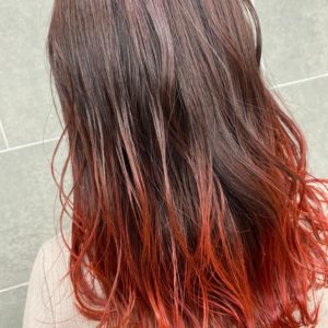 肩甲骨にかかる長さの毛先が赤色のヘアスタイル