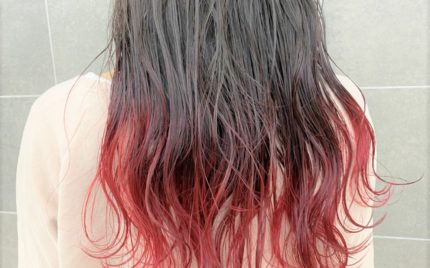 肩甲骨が隠れる程の長さの毛先が赤色のヘアスタイル