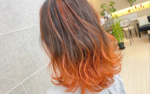 肩にかかる長さの部分的に橙色になっているヘアスタイル